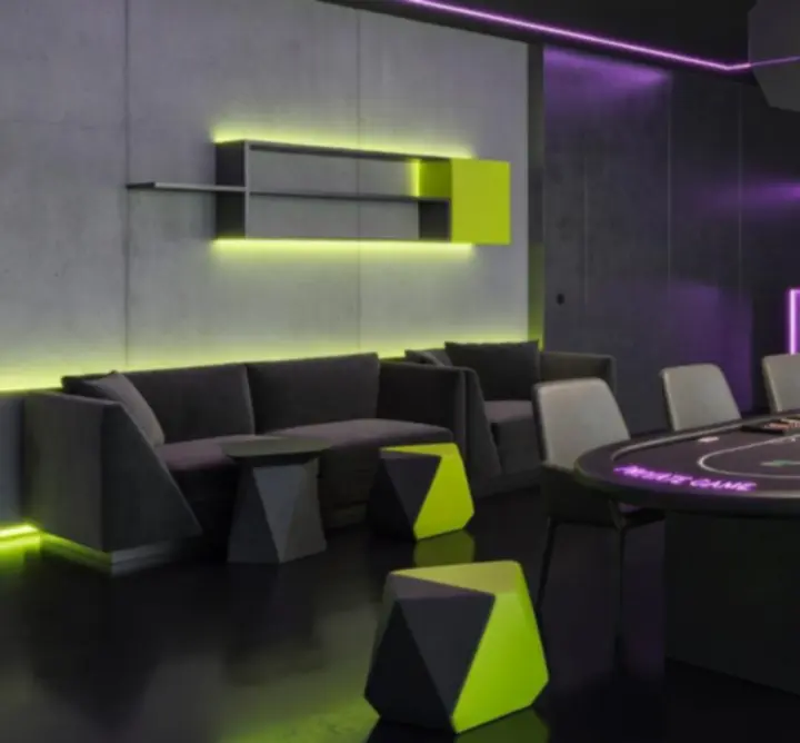 Wnętrze urban premium lounge z neonowym oświetleniem i stołami do gier przygotowanymi na wieczorne wydarzenie.